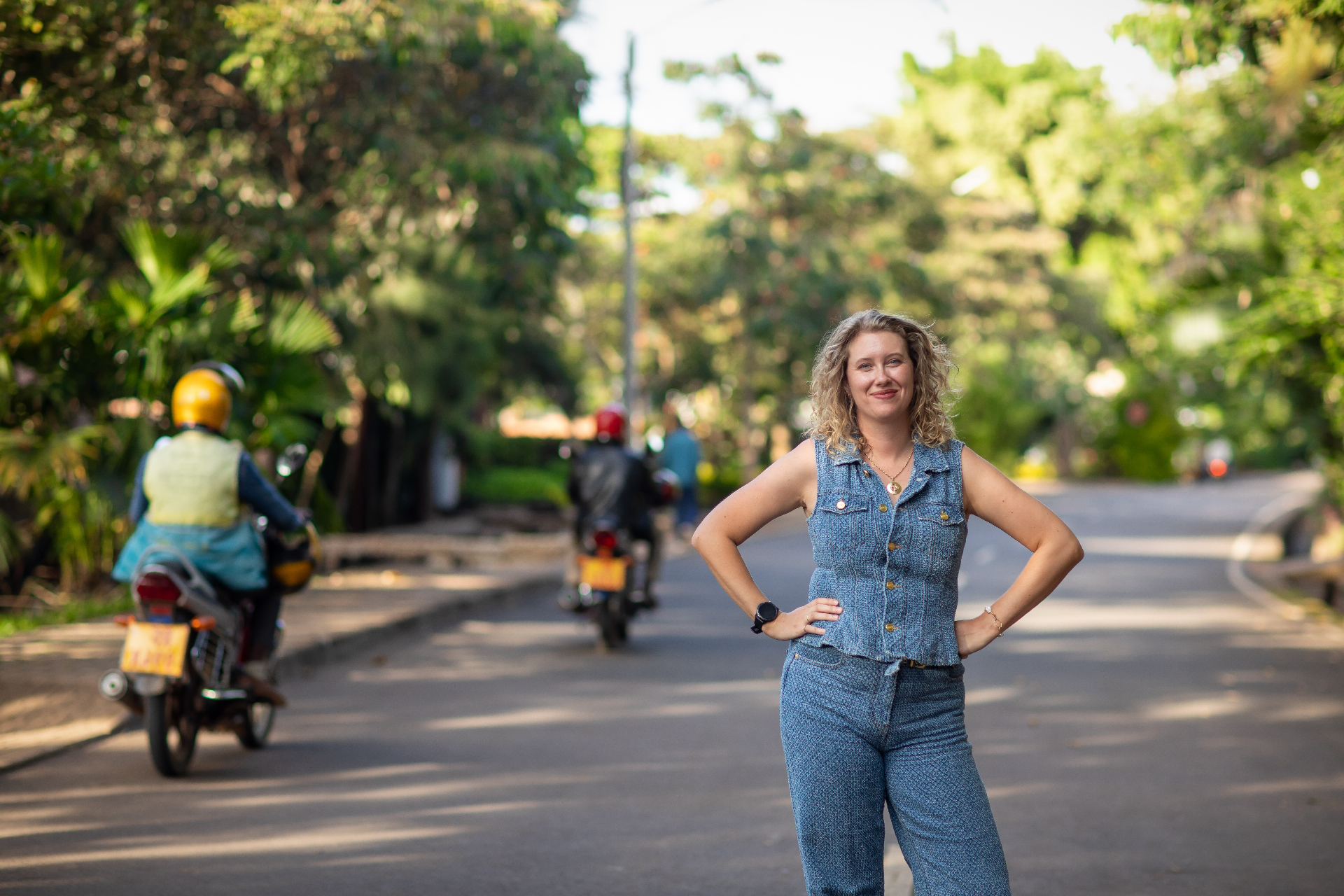 Yanna on a quiet Kigali street with moto-taxis passing