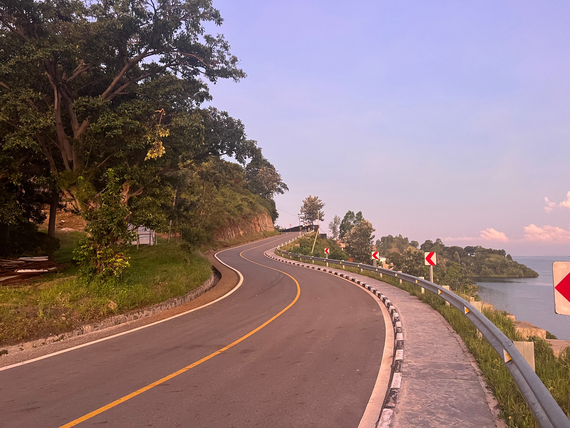 A winding tarmac road along Lake Kivu at dusk
